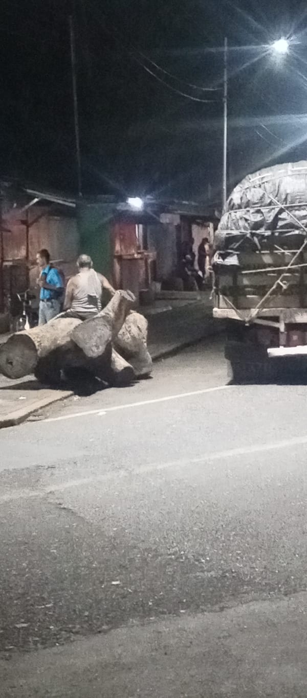 Man sits on tree trunk during nighttime in Tinaquillo