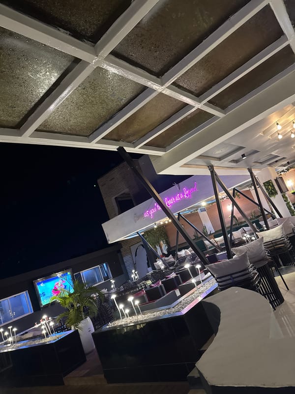 Night scene shows outdoor dining area and urban architecture