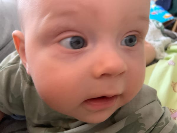 Baby in green camo shirt photographed at home in Kyiv