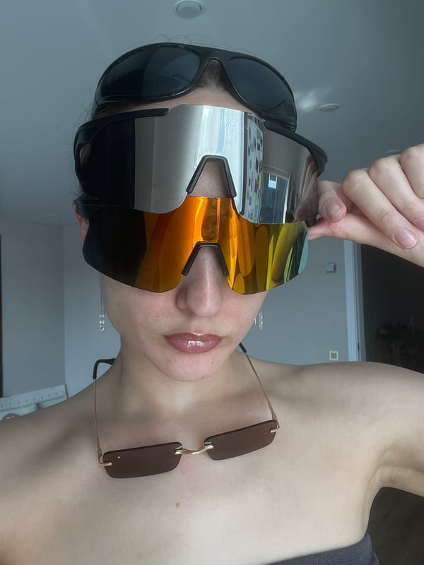 Woman wears multiple sunglasses indoors in Russian village