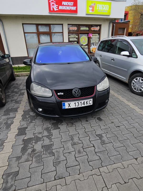 Black VW GTI parked with minivan in Dimitrovgrad Bulgaria