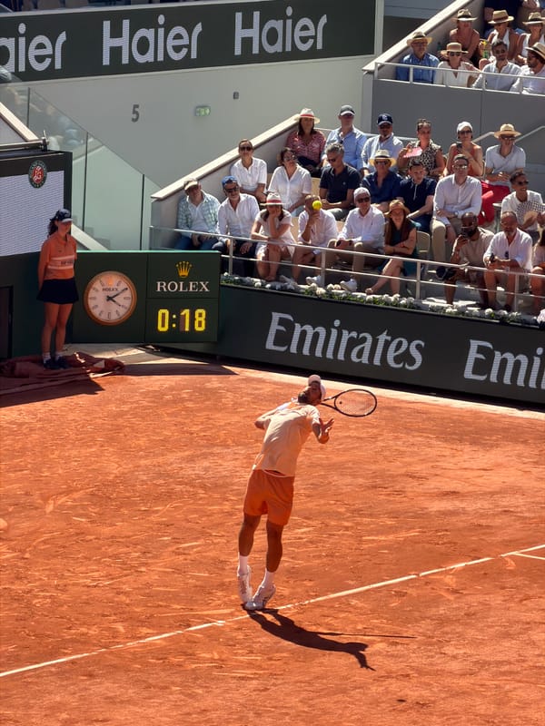 Tennis player serves at Roland Garros clay courts