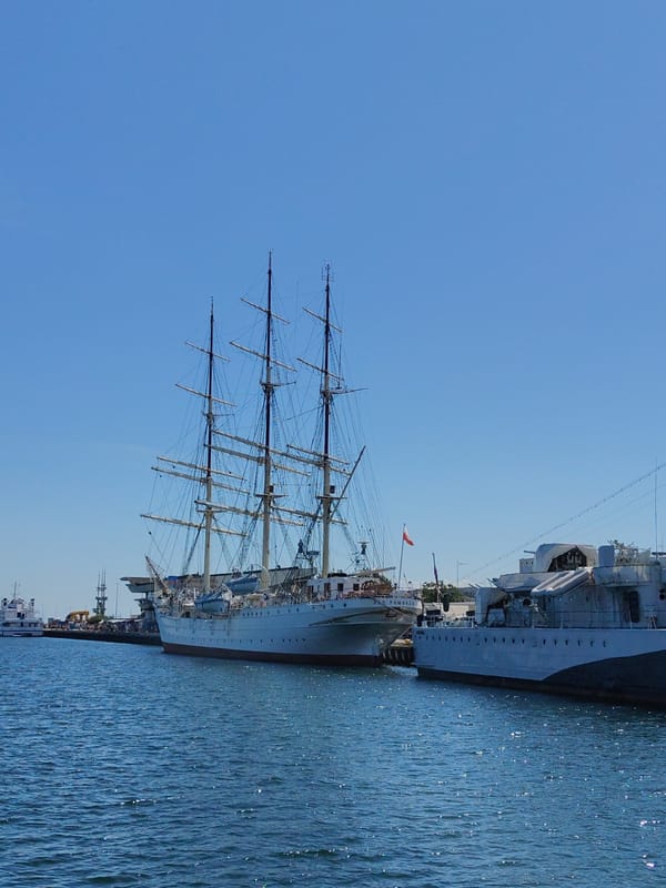 ORP Iskra and tall ships at Gdynia's sunny harbor