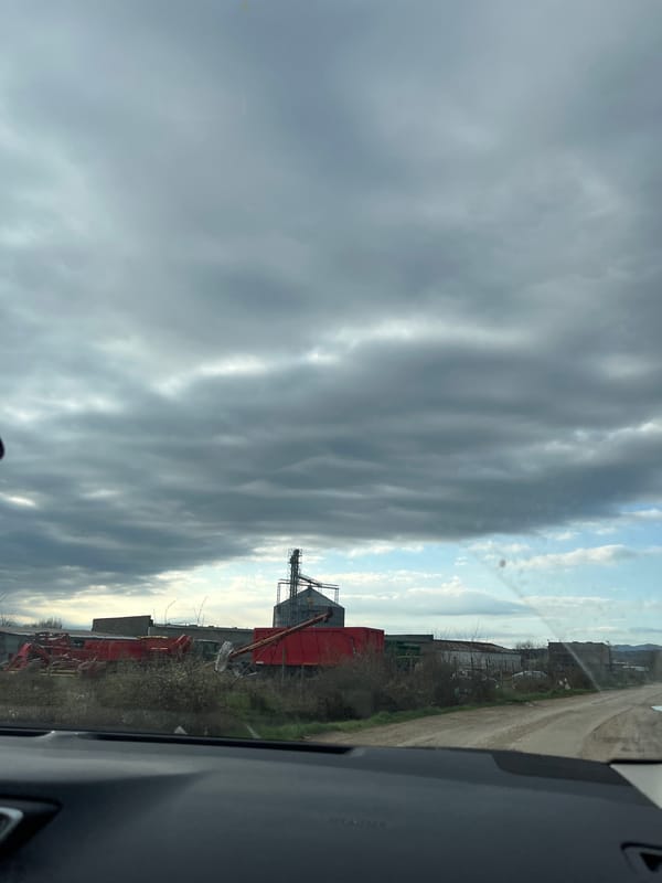 Vehicle passenger observes cloudy rural landscape near Vratsa, Bulgaria
