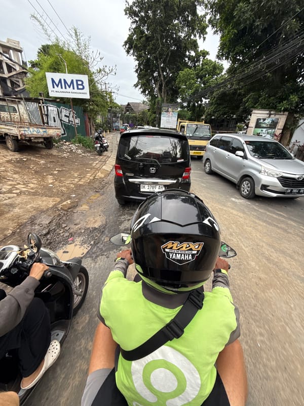 Motorcycle rider navigates Ubud streets under overcast skies