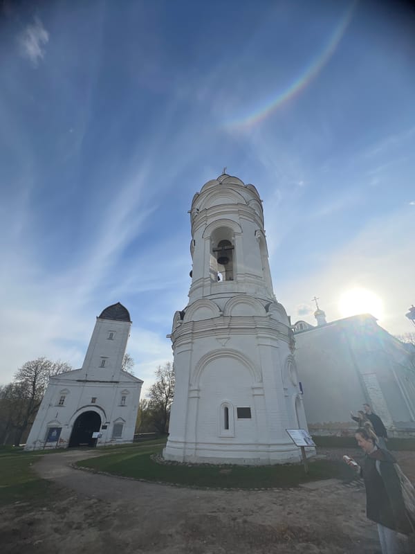Rainbow arches over Moscow's historic Kolomenskoye Church during sunny afternoon