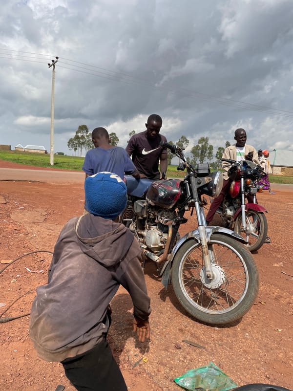 Roadside motorcycle repairs and daily movement in Wumat, Nigeria