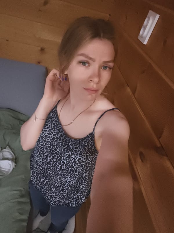 Woman holds hand to ear in wooden room