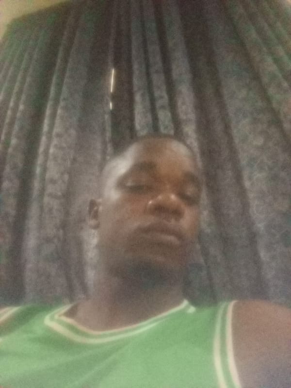 Man in green tank top photographed indoors