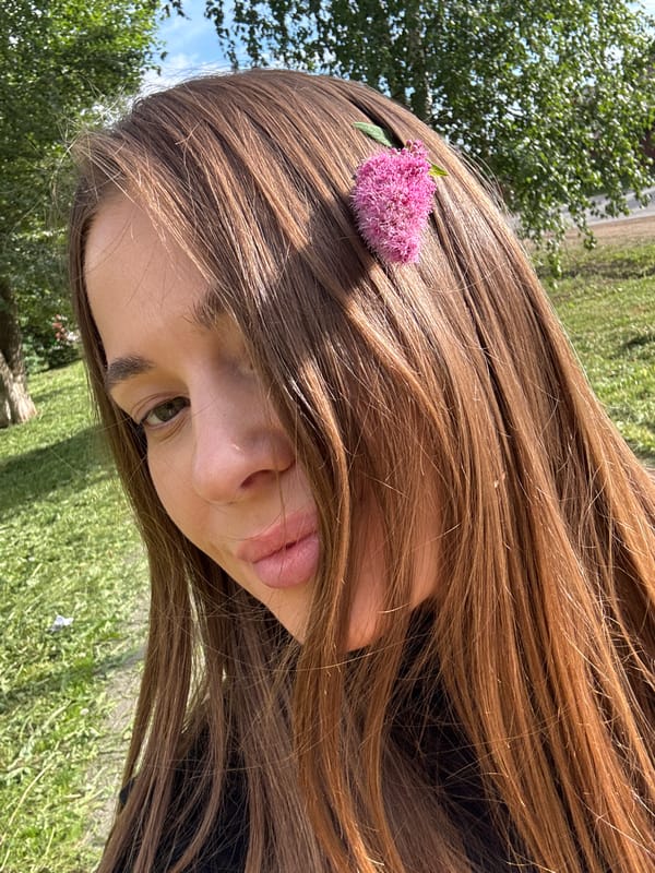 Playful outdoor selfies with pink flowers in Chernushka