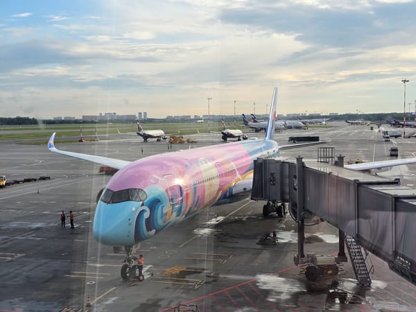 Vibrant blue wave livery aircraft parked at airport gate