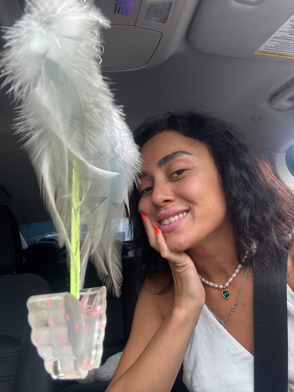Relaxed moment in a Tbilisi car, smiling with pearl necklace