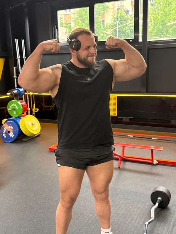 Muscular man flexes at gym, shows off biceps
