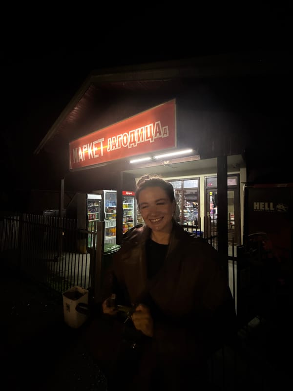Woman poses outside convenience store in Serbian town