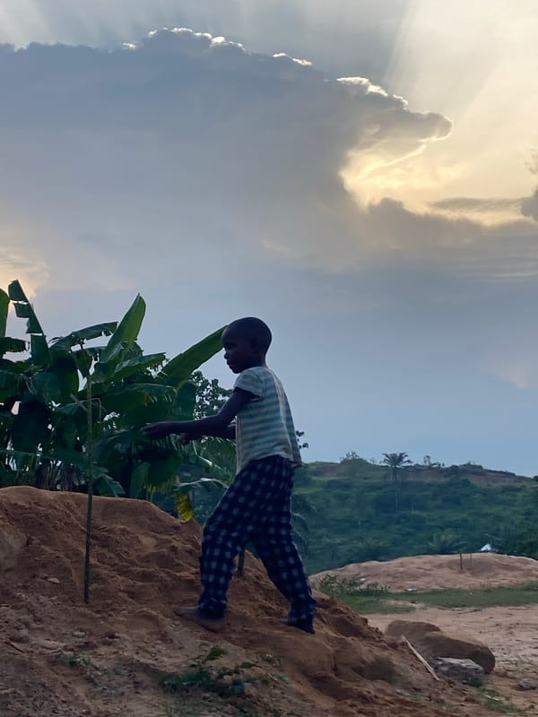 Person observed on soil mound amid banana plants in Ogbu