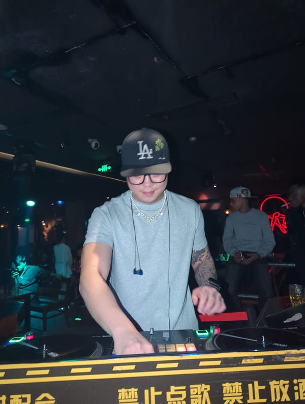 Nightclub scene documented in Liangjiang with dancing patrons, DJ