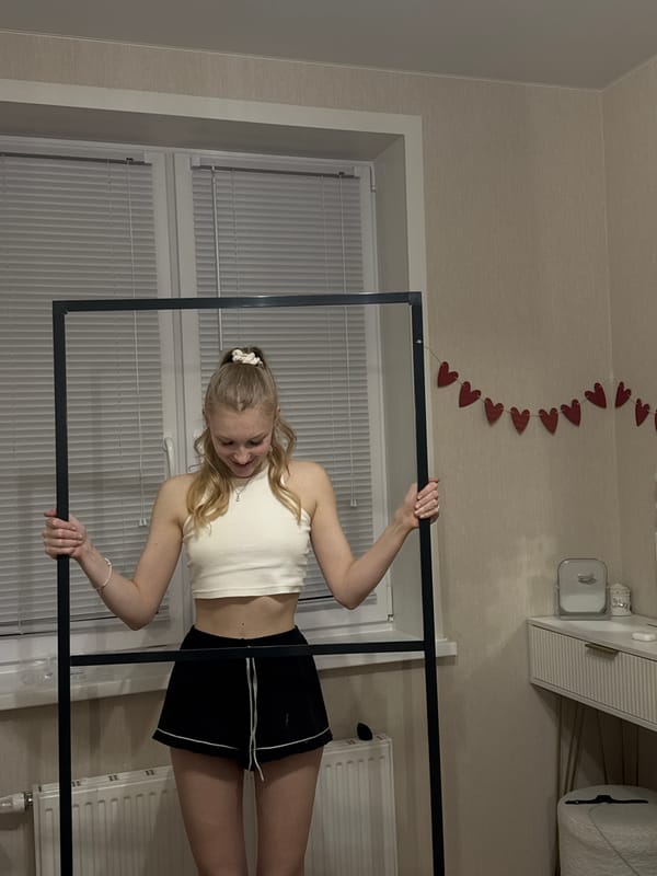 Woman poses with black frame in decorated room
