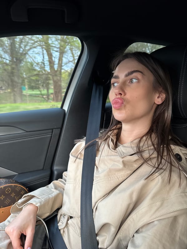 Woman poses for photos in car on Warsaw street