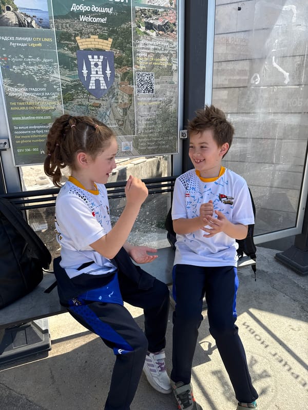 Two children sit together on bench in Meljine, Montenegro