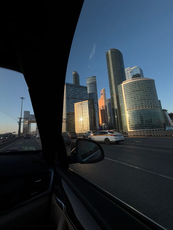 Driver photographs Moscow City skyline from elevated roadway
