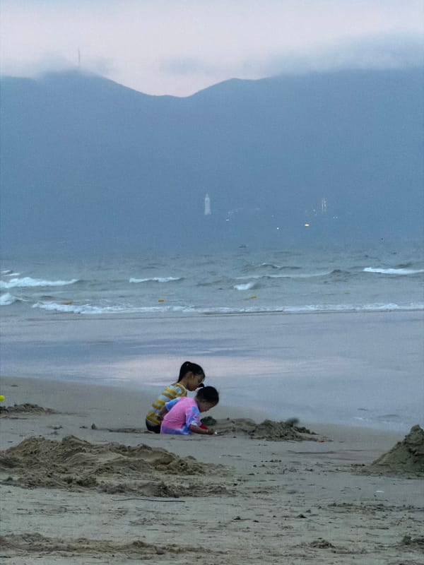 Children play on overcast Đà Nẵng beach during morning hours