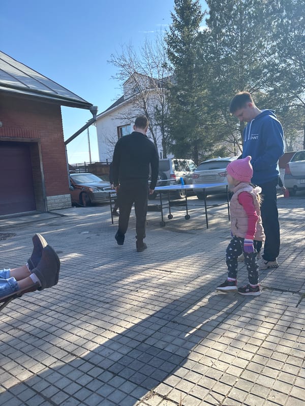 Family ping-pong gathering in sunny Ferma, Russia