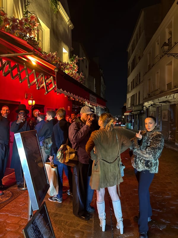 Nighttime gathering outside flower-decorated Paris storefront