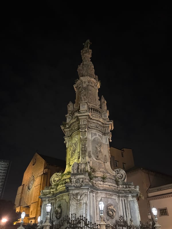 Evening social gathering documented near illuminated baroque monument