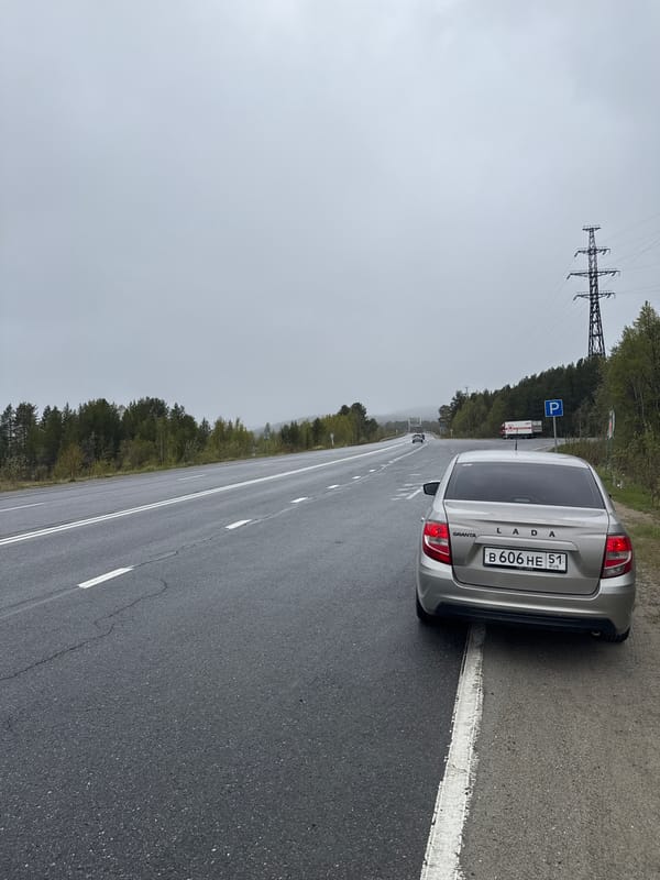 Silver Lada parked on wet road near Tik-Guba, Russia