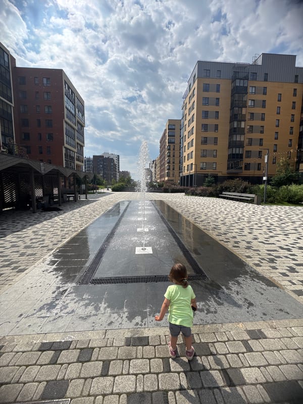 Kid and dog at a public fountain in Novoselye