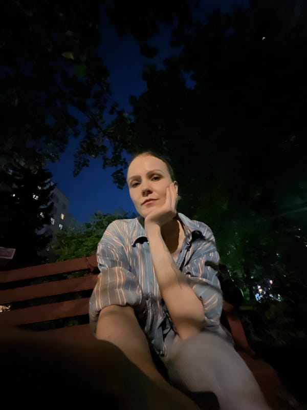 Person sits contemplatively on bench in Khimki evening