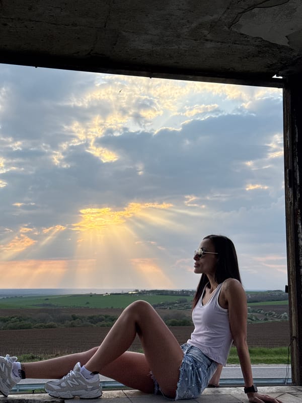Woman poses in window during dramatic sunset in Pleven