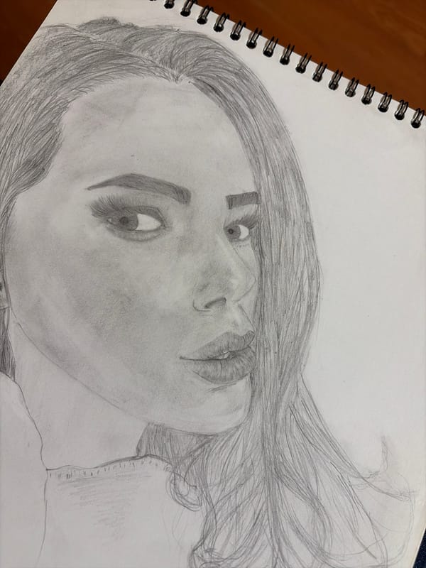 Artist sketches woman's portrait in spiral sketchbook session