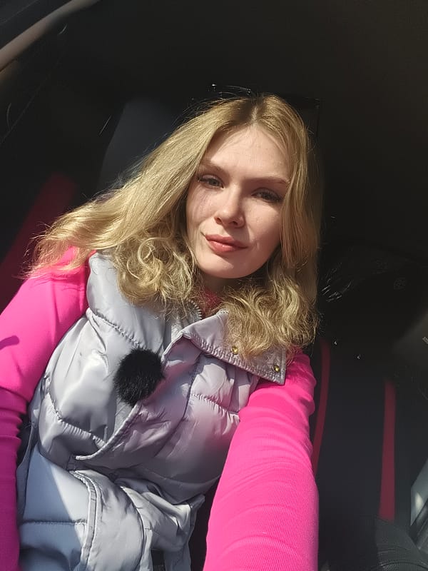 Woman in pink shirt observed in car interior, Izhevsk
