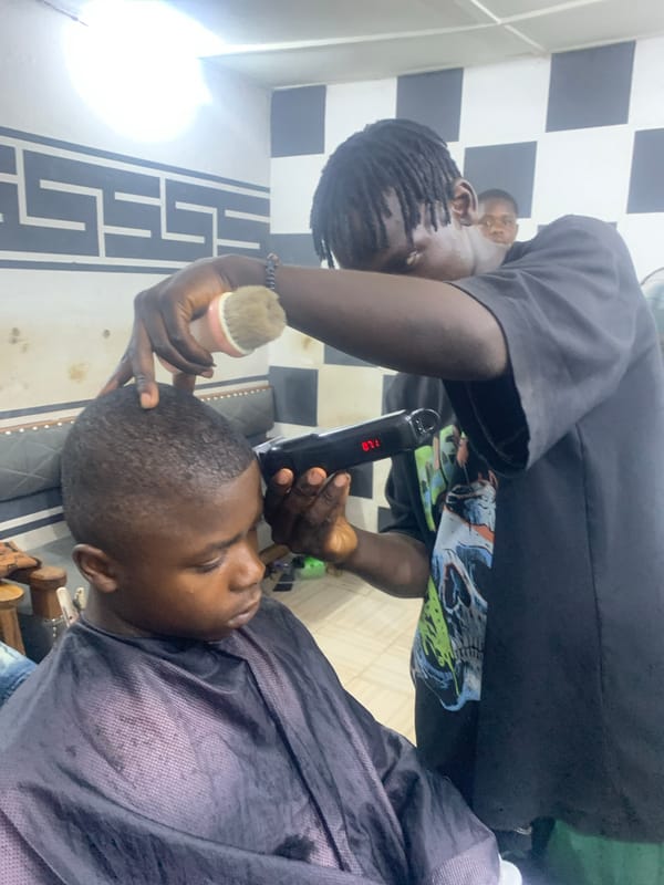 Barber cuts client's hair at Jos shop