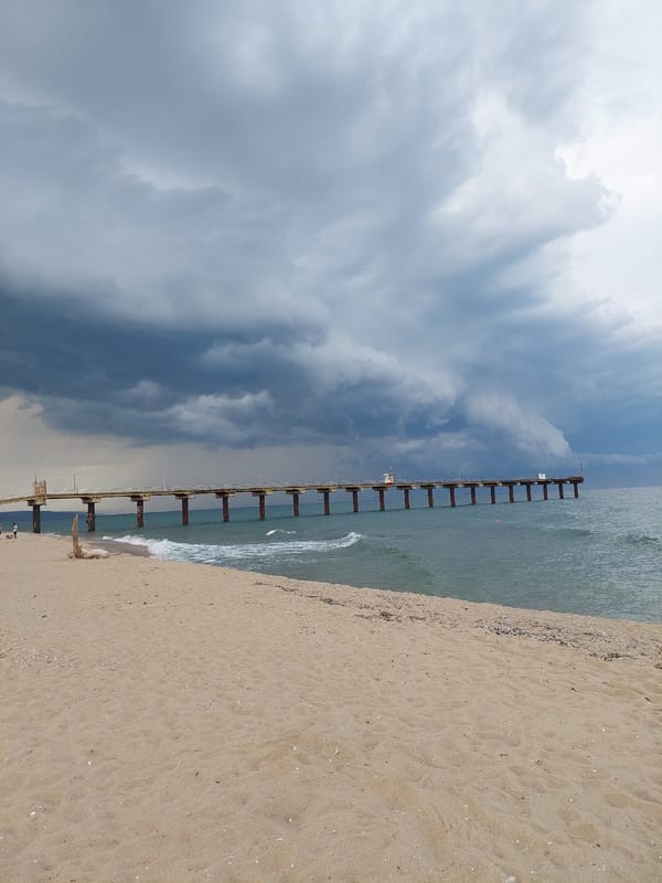 Shkorpilovtsi beach and Black Sea pier under stormy skies