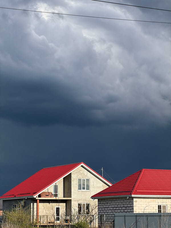 Person poses near construction site during storm in Rossiyskiy