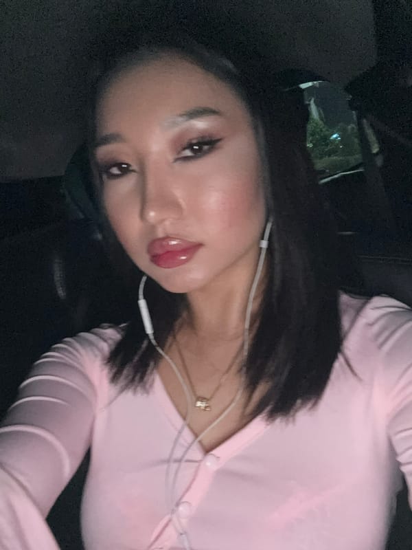 Woman photographed in pink outfit during vehicle travel in Kuta