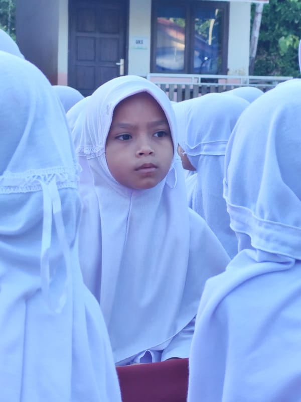 Students in uniform gather outdoors for what looks like a school activity.