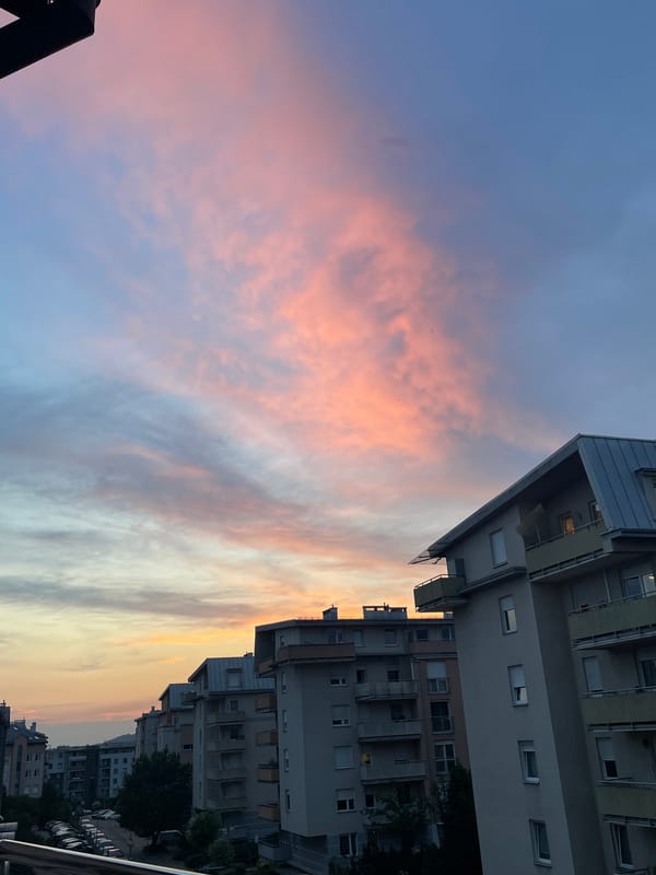 City apartment skyline glowing under a vivid evening sunset