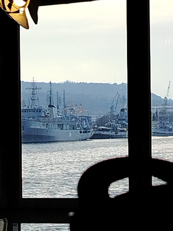 Harbor with naval vessels viewed through window in Varna