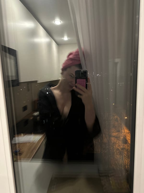 Woman takes selfie, drinks pink beverage in Kazan evening
