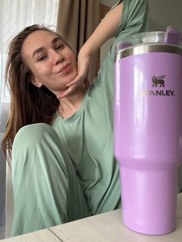 Woman drinks from purple Stanley tumbler in Kharnavy, Russia