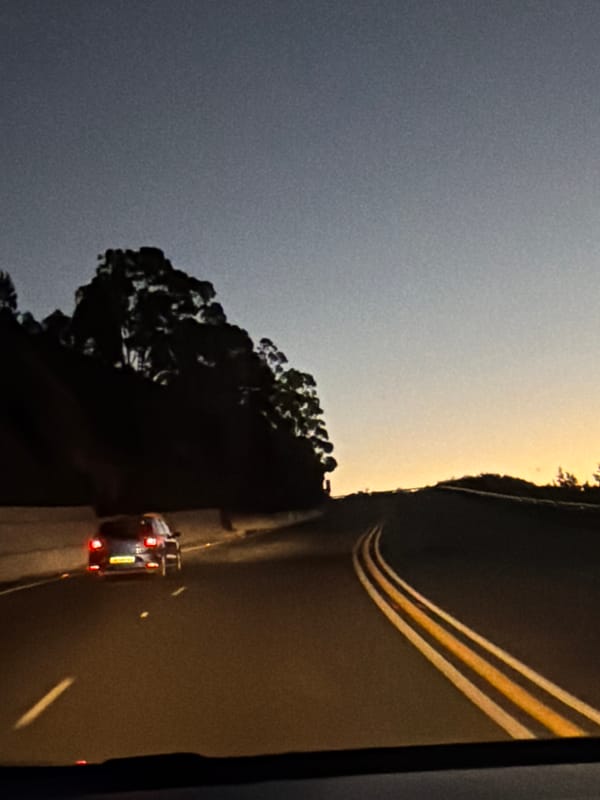 Car travels scenic Sir Lowry's Pass at twilight