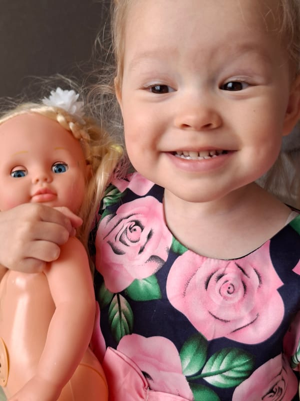 Young girl plays with dolls indoors during morning playtime