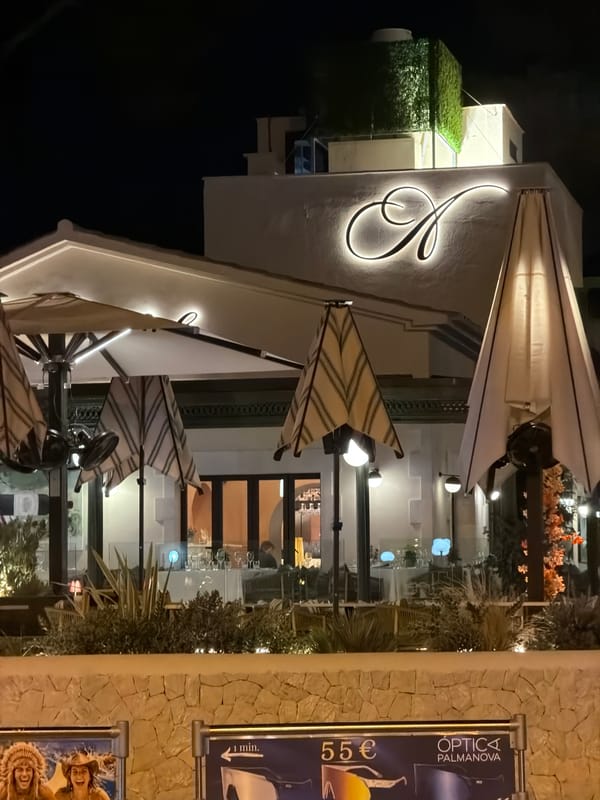 Palmanova at night: restaurant lights, palms, and oleander