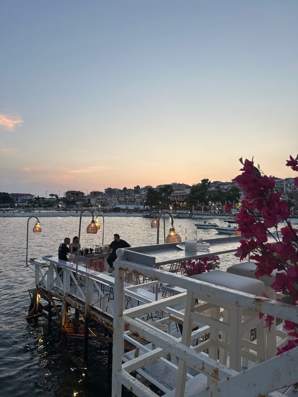 White pier dining over dark water at dusk