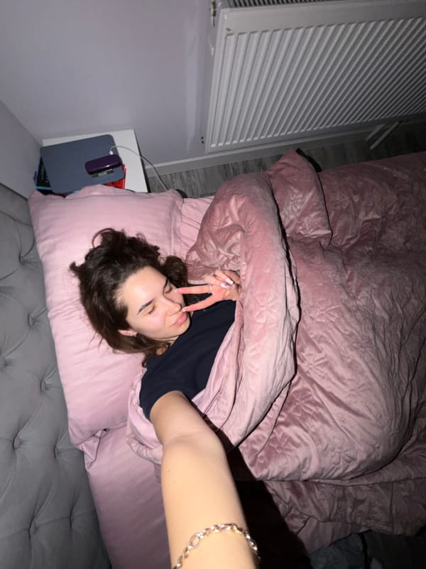 Woman relaxes in pink bedroom during evening in Dobrich