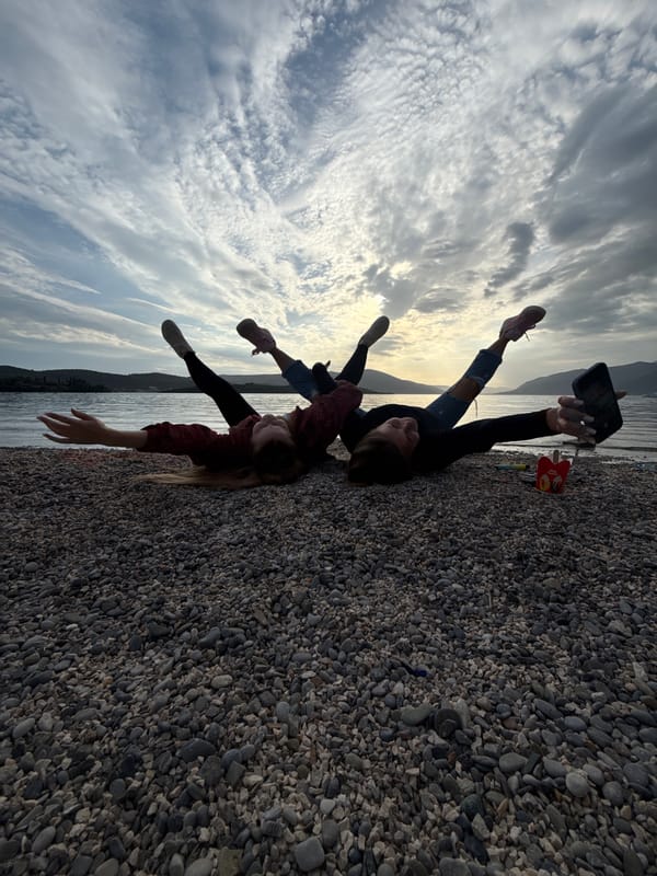Two women take selfies on Montenegro pebble beaches