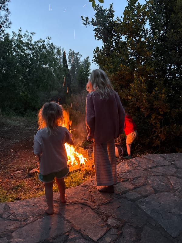 Children gather around campfire at twilight in Kfar Vradim